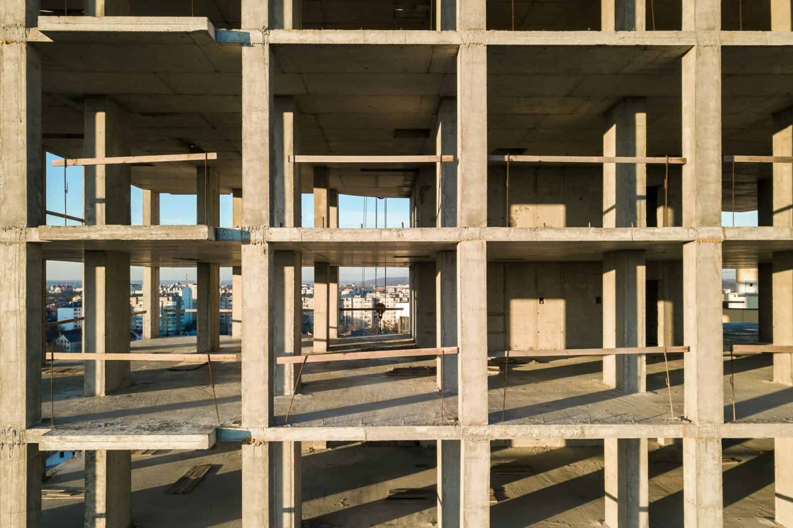 Aerial view of concrete frame of tall apartment building under construction in a city