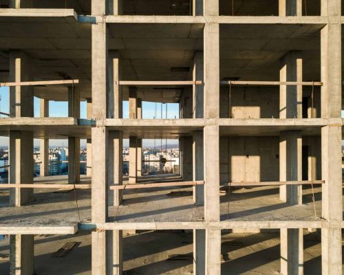 Aerial view of concrete frame of tall apartment building under construction in a city